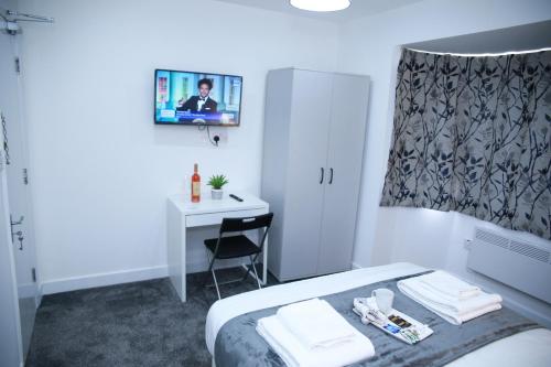 哈罗Stunning 2-Bed Apartment in Harrow的酒店客房配有一张床和一张带镜子的书桌