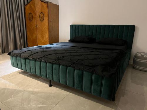 布加勒斯特APARTMENT 27 Old City的卧室内一张带绿色床头板的床