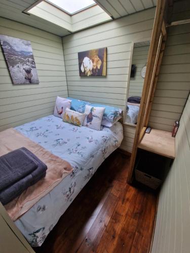 霍利黑德Stunning 1-Bed shepherd hut in Holyhead的一间小房间,房子里设有一张床铺