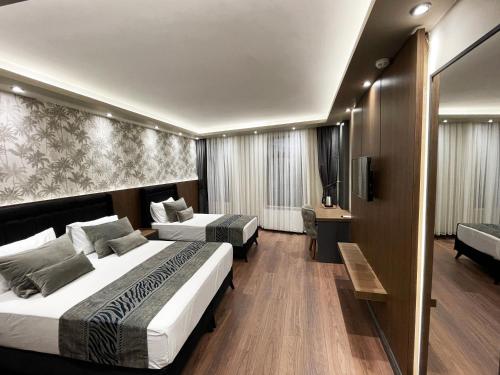伊斯坦布尔GRAND ÜSKÜDAR OTEL的酒店客房设有两张床和电视。