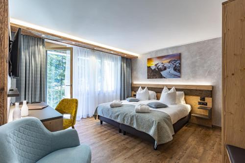 采尔马特海米祖思和埃瑞米尔酒店及Spa的配有一张床和一把椅子的酒店客房