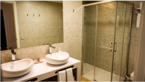 隆达隆达岑特洛公寓的一间带两个水槽和玻璃淋浴间的浴室