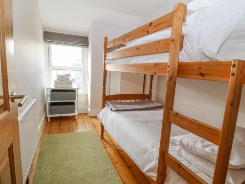 波特马多克Y Castell Apartment 3的一间卧室设有两张双层床和一扇窗户。