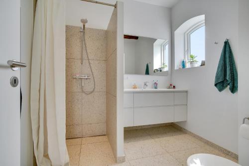 洛肯Pakhuset的带淋浴和盥洗盆的白色浴室