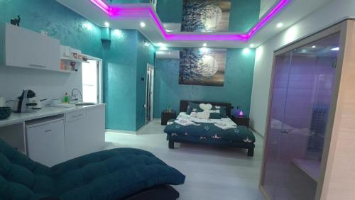 帕拉钦Apartman Melody的一间设有一张床的客房和一个带紫色灯的厨房