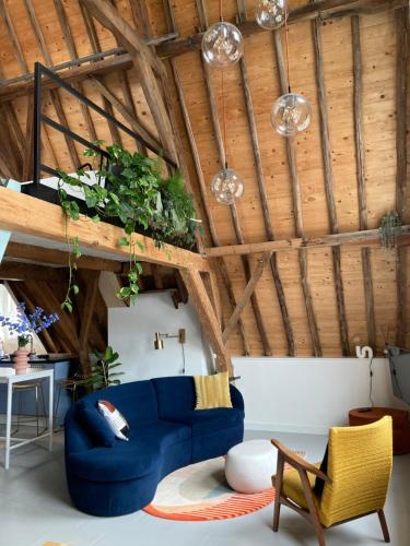 米德尔堡Number 9 holiday apartments的客厅设有蓝色的沙发和木制天花板。
