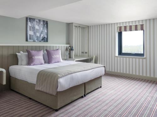 阿伯丁阿伯丁乡村酒店的一间卧室配有一张带紫色枕头的大床