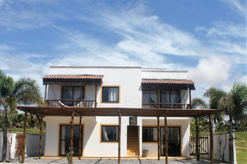 特赖里Aldeias Guajiru Apart的带阳台和棕榈树的白色房屋