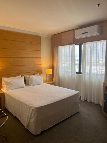 圣保罗Lindo Flat ao Lado do Aeroporto de Congonhas的卧室设有一张白色大床和一扇窗户。