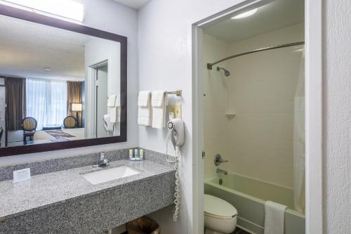 彭萨科拉Rest and Relax Inn的一间带水槽、卫生间和镜子的浴室