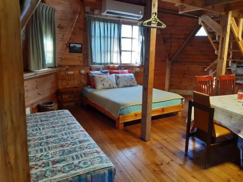 Manotבקתת עץ בחורש במנות - דום גיאודזי - Wooden cabin in Manot的小木屋内一间卧室,配有一张床