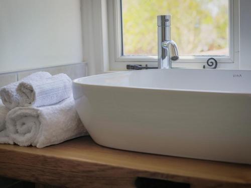 温彻斯特Mallard Cottage的浴室内木制柜台上的白色浴缸