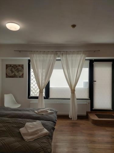 鲁塞Студио 55的一间卧室配有床和两个带窗帘的窗户