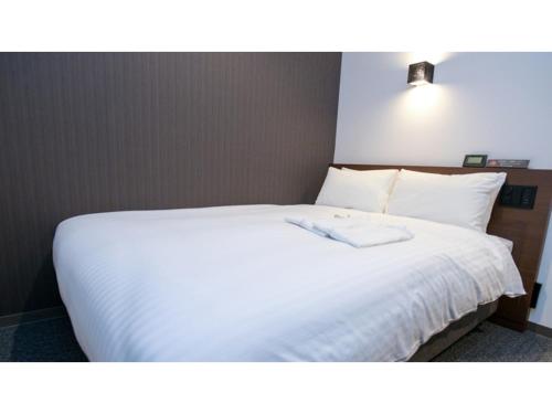 福冈ＹＯＵ ＳＴＹＬＥ ＨＯＴＥＬ ＨＡＫＡＴＡ - Vacation STAY 16027v的卧室配有白色床单和白色床。