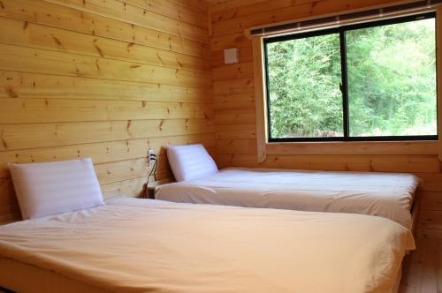 壹岐市NEXX IKI - Vacation STAY 16966v的小木屋内的两张床,设有窗户