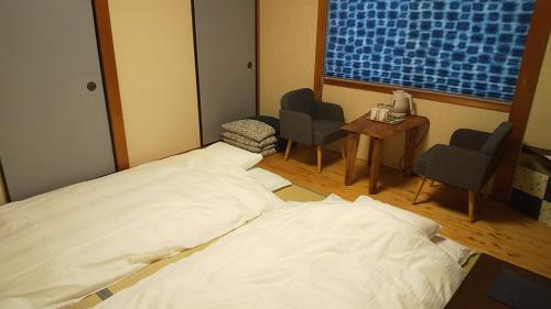 京都Guest House Nishimura - Vacation STAY 13438的一间医院房间,配有床和两把椅子,并设有一个窗户