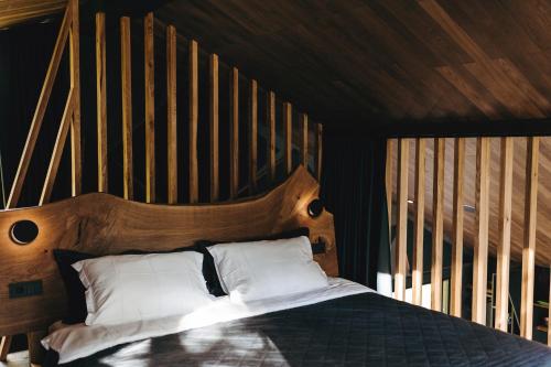 VöölaPrivate Time的一间卧室配有一张带木制床头板的床