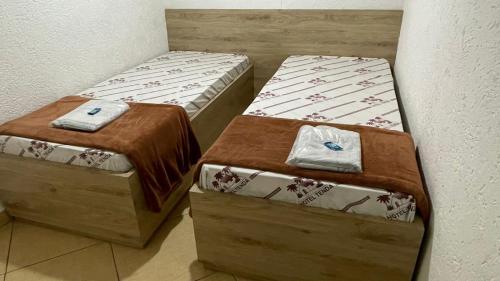 圣保罗Hotel Tenda Brigadeiro SP的小客房内的两张床和毛巾