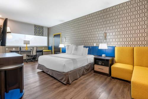 列克星敦GLō Best Western Lexington的酒店客房设有一张大床和一张书桌。