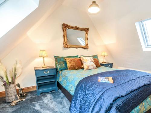 赖盖特Little Palm House的一间卧室配有蓝色的床和镜子