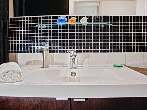布拉迪斯拉发微风公寓的浴室设有黑色瓷砖,配有白色水槽。