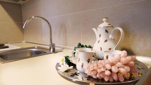 佩弗卡里Smaragdi Studios的厨房柜台上备有杯子、茶壶和葡萄的托盘