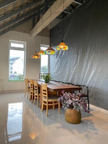 大叻Century House的用餐室配有桌椅和灯
