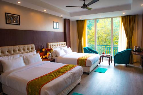 BhurtukAvianna Gangtok Resort & Spa的酒店客房设有两张床和窗户。