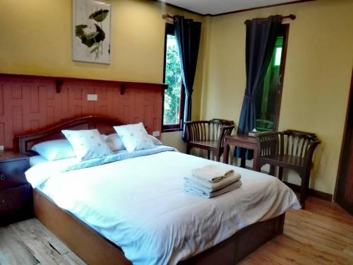 大城琅勃拉邦村庄酒店的卧室配有一张带两把椅子的白色大床