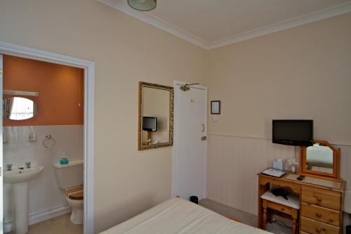 韦茅斯克努比亚宾馆的浴室设有床、水槽和镜子