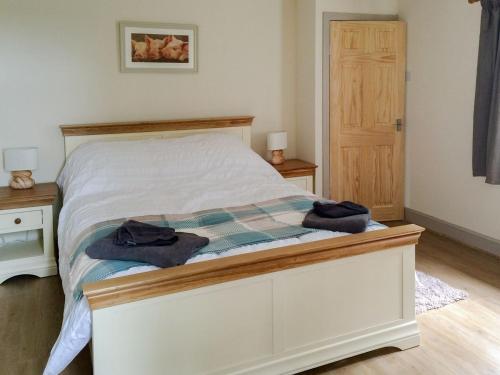 WhitekirkCauldside West Cottage的一间卧室配有一张床,上面有两条毛巾