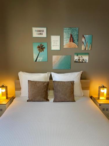 佩里格Caribbean Spirit的一间卧室配有一张带两盏灯的床,墙上挂有图片