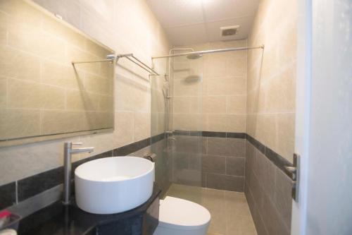 头顿Hoàng Bách Hotel的浴室配有卫生间、盥洗盆和淋浴。