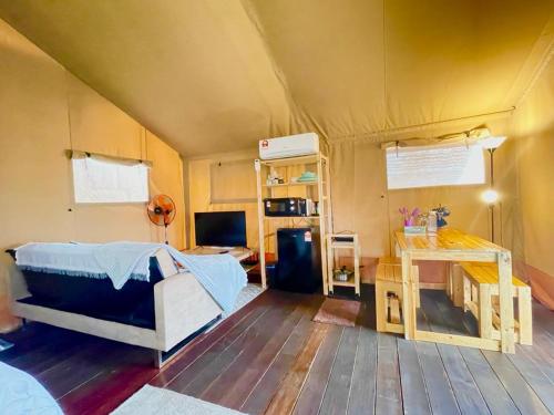 佩纳利克村Rembulan Escape - Beachfront safari tent的帐篷内带一张床和一张书桌的房间
