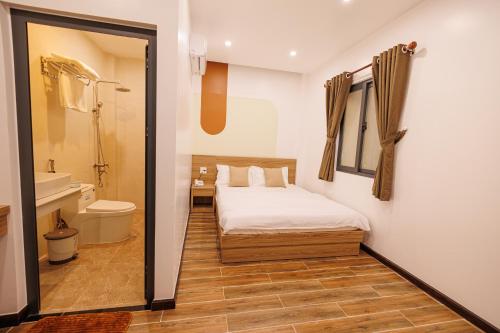 Bạc LiêuHappy Hotel的一间卧室配有一张床,浴室设有卫生间