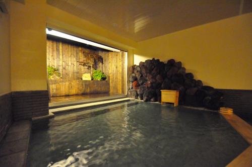 日光日光季之游酒店(Nikko Tokinoyuu)的游泳池,位于一个有一堆木柴的房间