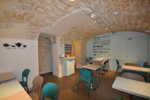 巴黎圣乔治拉法耶特酒店的一间带桌椅和石墙的餐厅