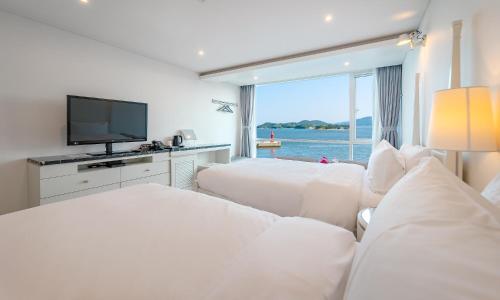 泗川Owl Hotel的酒店客房设有两张床和一台平面电视。