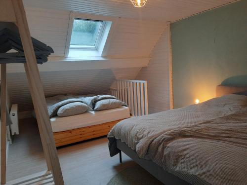 赫拉尔兹贝亨Huisje op de Muur van Geraardsbergen的一间卧室配有双层床和窗户。