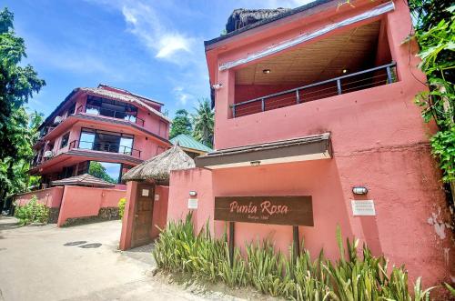 长滩岛Signature Boracay Punta Rosa formerly Punta Rosa Boutique Hotel的粉红色的建筑,前面有标志
