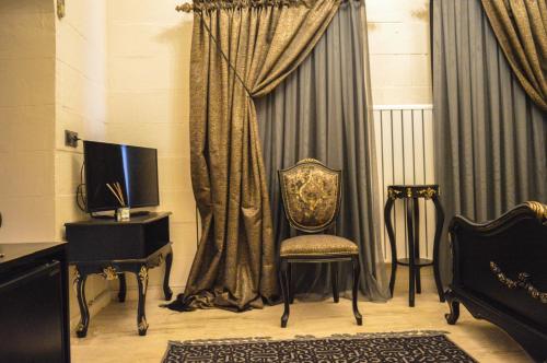 AcırlıAslanbey Konağı Butik Otel的配有窗帘和电视的室内椅子