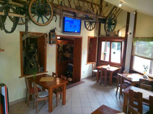 兹瓦尔东Gościniec Halka的一间带桌椅的餐厅以及墙上的电视