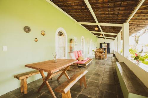 帕里普埃拉Villa Ostello Pousada的一间带木桌和长凳的用餐室