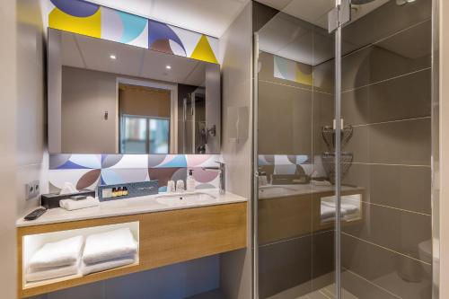 鹿特丹Postillion Hotel WTC Rotterdam的一间带水槽和淋浴的浴室