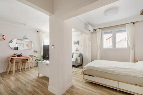 塞萨洛尼基Lovely small (parterre) apartment in Thessaloniki的白色卧室配有床和书桌
