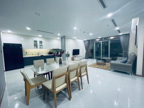胡志明市Landmark Plus - Vinhomes AirBnb的厨房以及带桌椅的起居室。