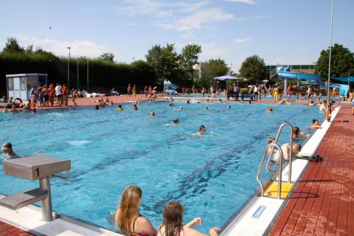 埃尔姆山麓克尼格斯卢特尔克恩纳斯登酒店的一群人在游泳池游泳