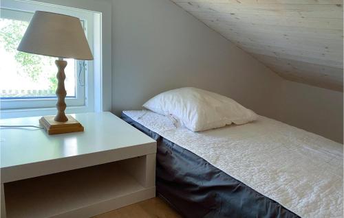 GnisvärdBeautiful Home In Gotlands Tofta With Kitchen的一间卧室配有一张带灯和窗户的床