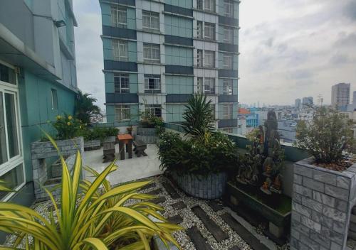 胡志明市凯欢公寓式酒店的一座种植了植物的阳台和一座高大的建筑