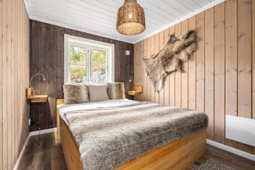 LonaLibehi的卧室配有一张床铺,位于带木墙的房间内